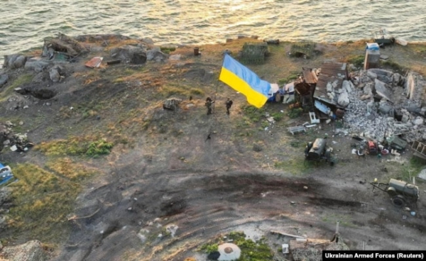 Українські бійці встановлюють національний прапор на острові Зміїний у Чорному морі (Одеська область), 7 липня 2022 року. Раніше, після тривалих інтенсивних ударів ЗСУ, російські військові, зазнавши великих втрат, залишили острів