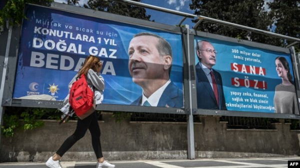 Жінка проходить повз рекламні щити з портретами кандидатів у президенти Туреччини Реджепа Тайїпа Ердогана (ліворуч) та Кемаля Киличдароглу. Шанліурфа, Туреччина, 28 квітня 2023 року
