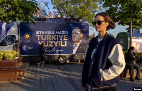 Жінка проходить повз передвиборчий автомобіль із зображенням президента Туреччини Тайїпа Ердогана та гаслом «Століття Туреччини починається. Стамбул готовий». Стамбул, 2 травня 2023 року