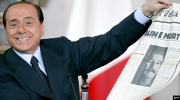 Сильвіо Берлусконі з газетою із портретом Сталіна