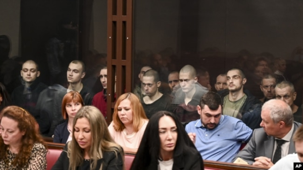 На задньому плані (за склом) ув’язнені українські громадяни в суді у російському Ростові-на-Дону, більшість із них – військовополонені, бійці полку «Азов». Росія, Ростов-на-Дону, 14 червня 2023 року
