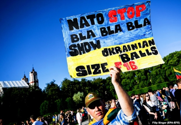 Чоловік тримає плакат, коли люди збираються на концерт #UkraineNato33 на підтримку України під час саміту НАТО. Вільнюс, Литва, 11 липня 2023 року