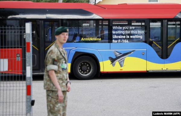 Натівський автобус з написами «Озброюйте Україну» та «Поки ви чекаєте на цей автобус, Україна чекає на F-16», припаркований біля місця проведення саміту НАТО у столиці Литви. Вільнюсі 11 липня 2023 року