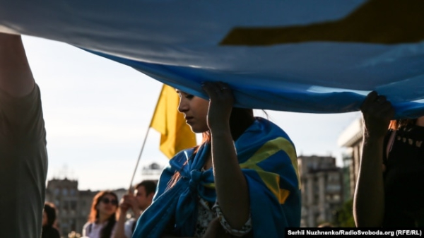 Кримчанка тримає велике полотно кримськотатарського прапора на Майдані Незалежності. Київ, 26 червня 2018 року. Ілюстраційне фото