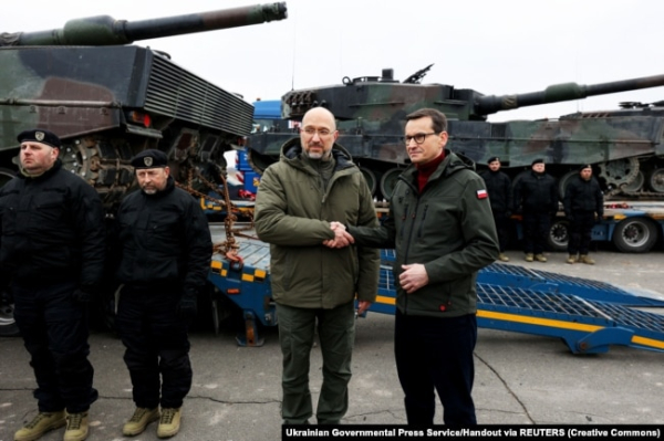 Керівники урядів України і Польщі, Денис Шмигаль та Матеуш Моравецький (праворуч), біля перших танків Leopard 2, доставлених із Польщі до України, 24 лютого 2023 року