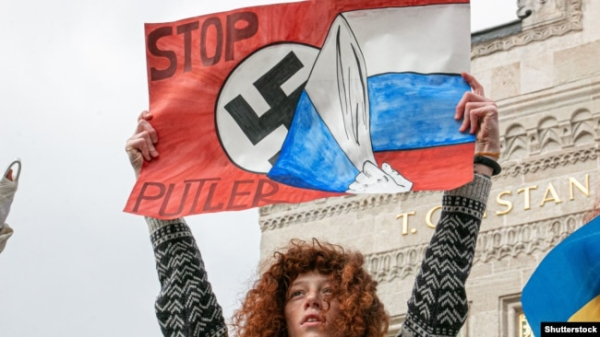 Жінка з плакатом під час протесту проти вторгнення Росії в Україну. Стамбул, Туреччина, 27 лютого 2022 року