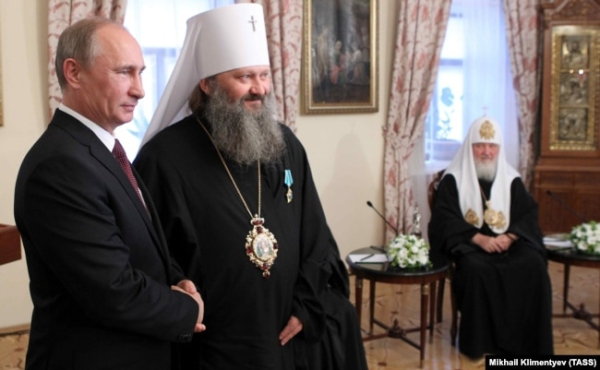 Президент Росії Володимир Путін (ліворуч) під час вручення державної нагороди Росії наміснику Києво-Печерської лаври митрополиту УПЦ (Московського патріархату) Павлу (Петру Лебідю) (другий зліва). Праворуч – патріарх Московський Кирило. Київ, 27 липня 2013 року