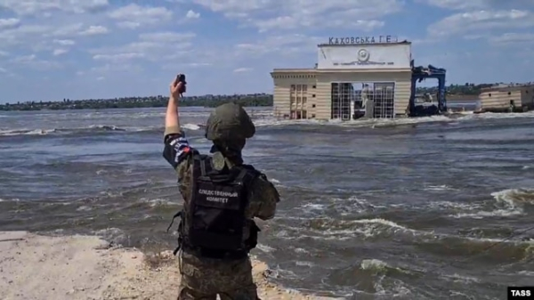 Представник окупаційних військ Росії на лівому березі Дніпра стоїть навпроти знищеної Каховської ГЕС, Україна, червень 2023 року