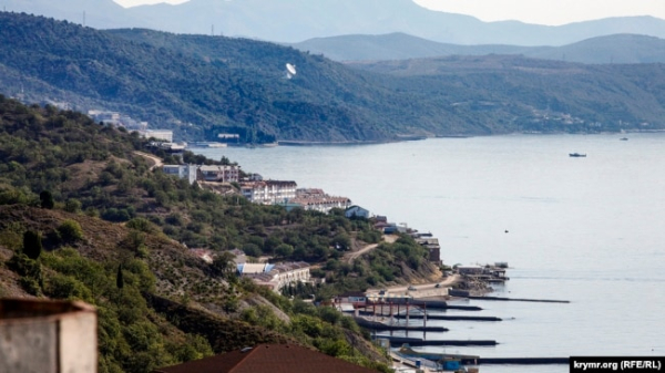 Узбережжя Чорного моря біля селища Сонячногірське під Алуштою, на дальному плані в Кримських горах видно велику супутникову антену російської військової частини