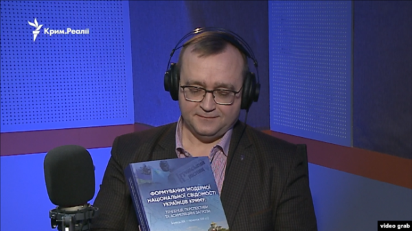 Історик Андрій Іванець демонструє монографію у студії Радіо Крим.Реалії