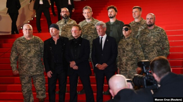 Боно, Едж та Шон Пенн разом із українськими військовослужбовцями на червоній доріжці 78-го Каннського кінофестивалю перед показом документального фільму «Боно: Історії капітуляції». Канни, Франція, 16 травня 2025 року