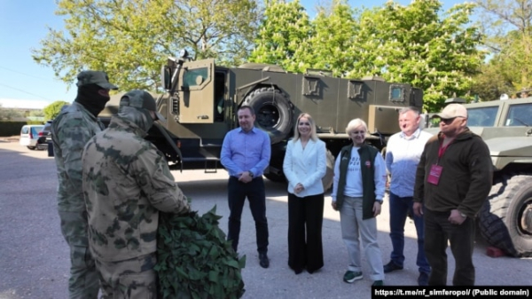 Представники сакського санаторію «Північне сяйво» та кримські активісти російського «Народного фронту» передають маскувальні сітки російським військовим під час повномасштабного вторгнення РФ в Україну, травень 2025 року