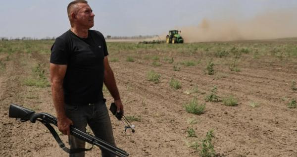 Олександр Гордієнко на полі, з рушницею від дронів та детектором / Фото: Суспільне-Херсон